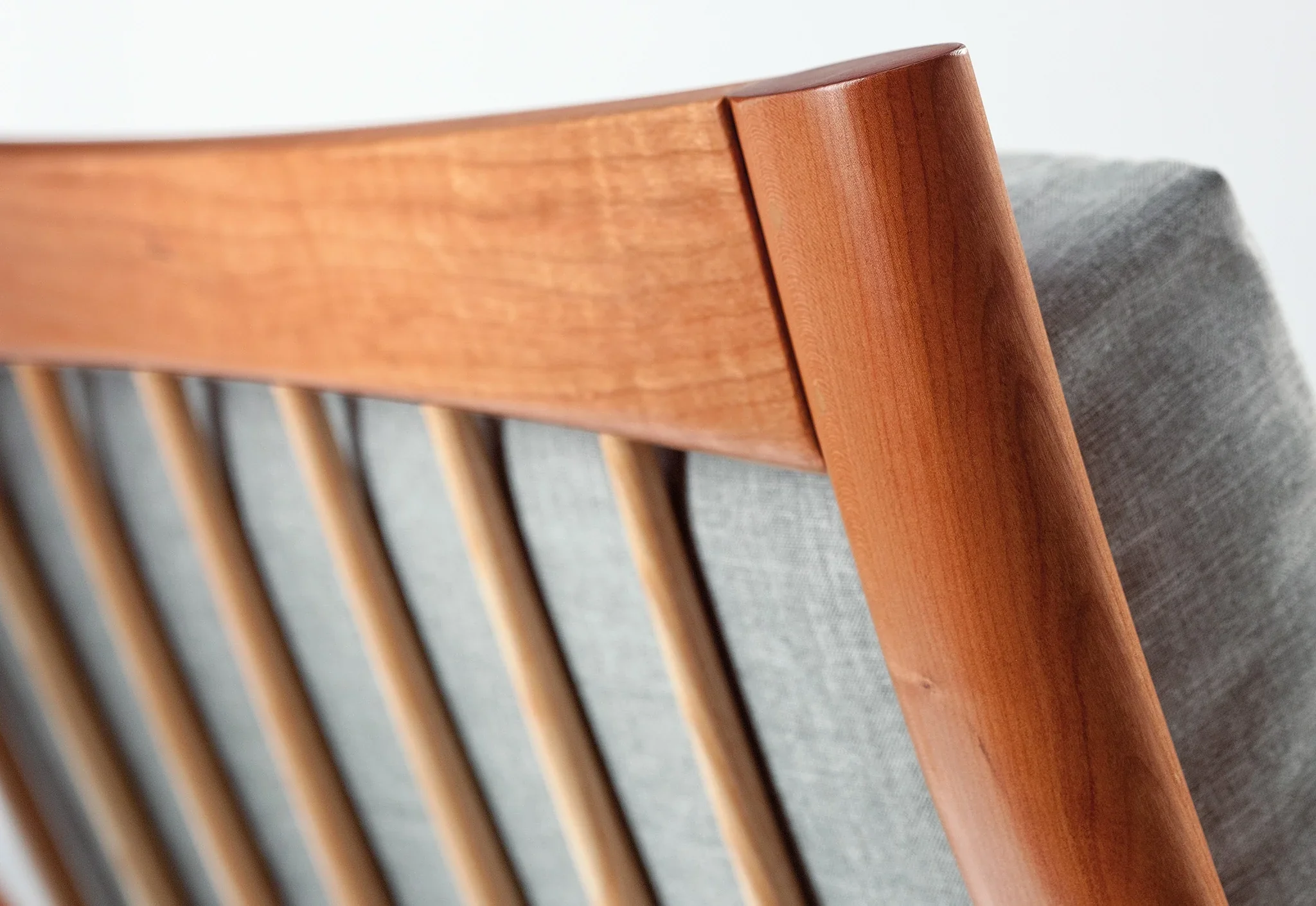 Lounge Chair - Designed with sweeping, curved arms, slender spindles along the back, and slender, gently raked legs