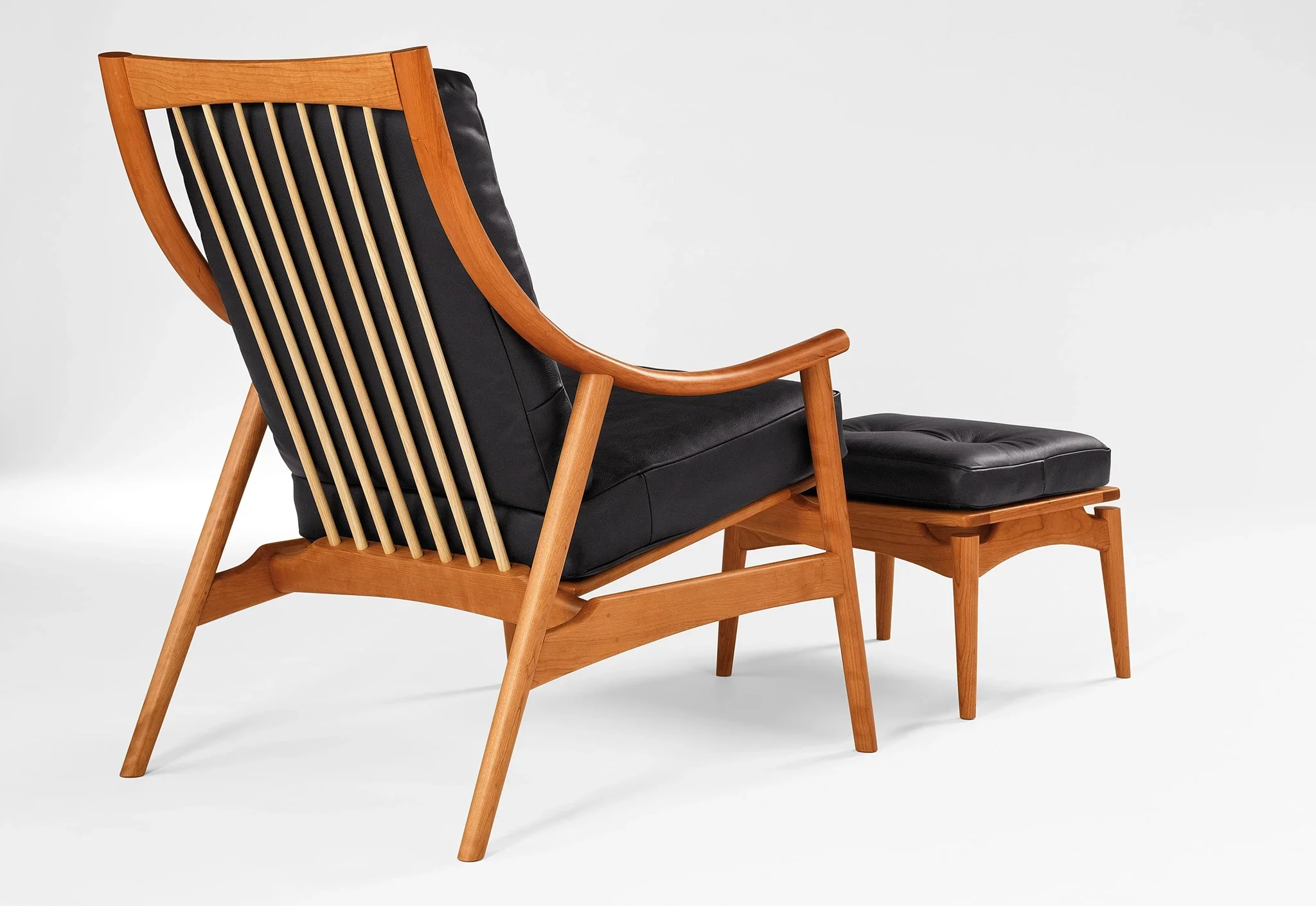 Lounge Chair - Designed with sweeping, curved arms, slender spindles along the back, and slender, gently raked legs