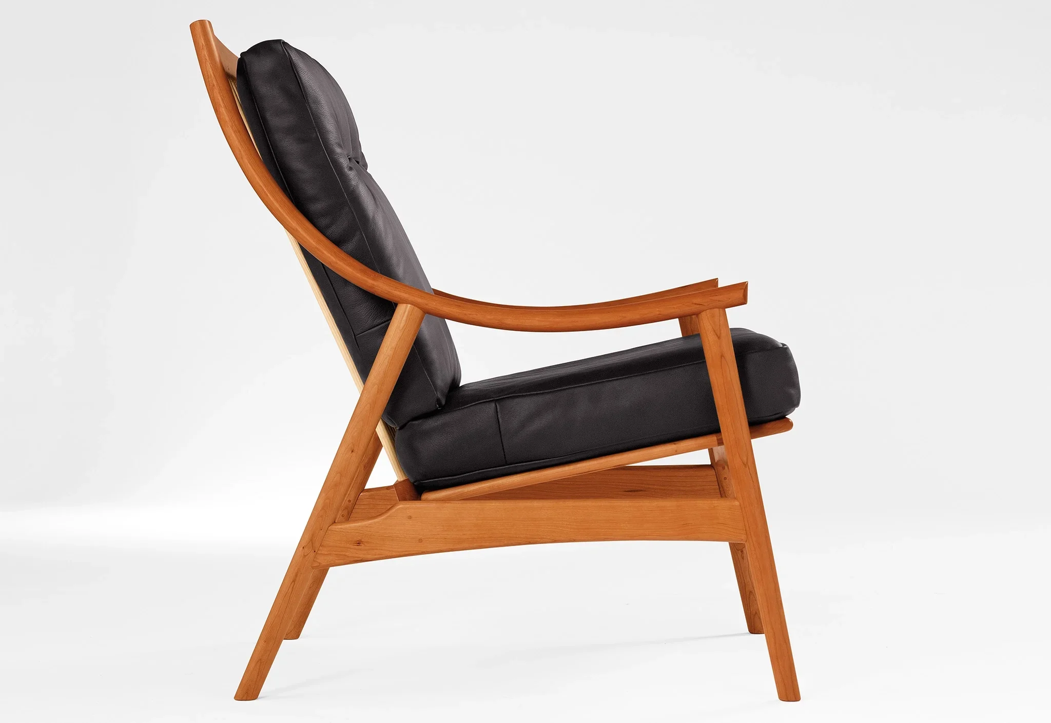 Lounge Chair - Designed with sweeping, curved arms, slender spindles along the back, and slender, gently raked legs